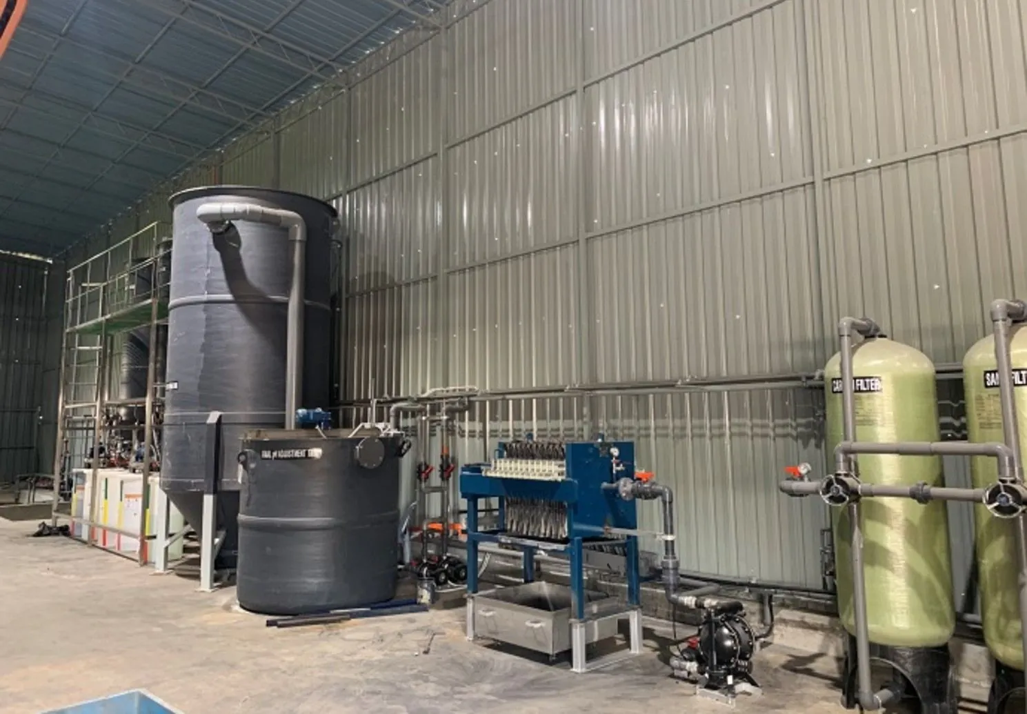 Grey pH adjustment tank beside the filter press and filter columns